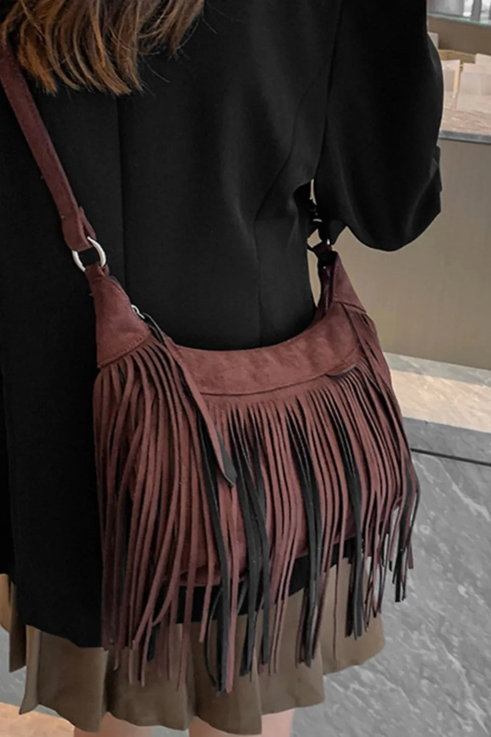 Woman wearing a Suede Fringe Adjustable Strap Shoulder Bag with fringes, showcasing the bag's stylish design and adjustable strap.