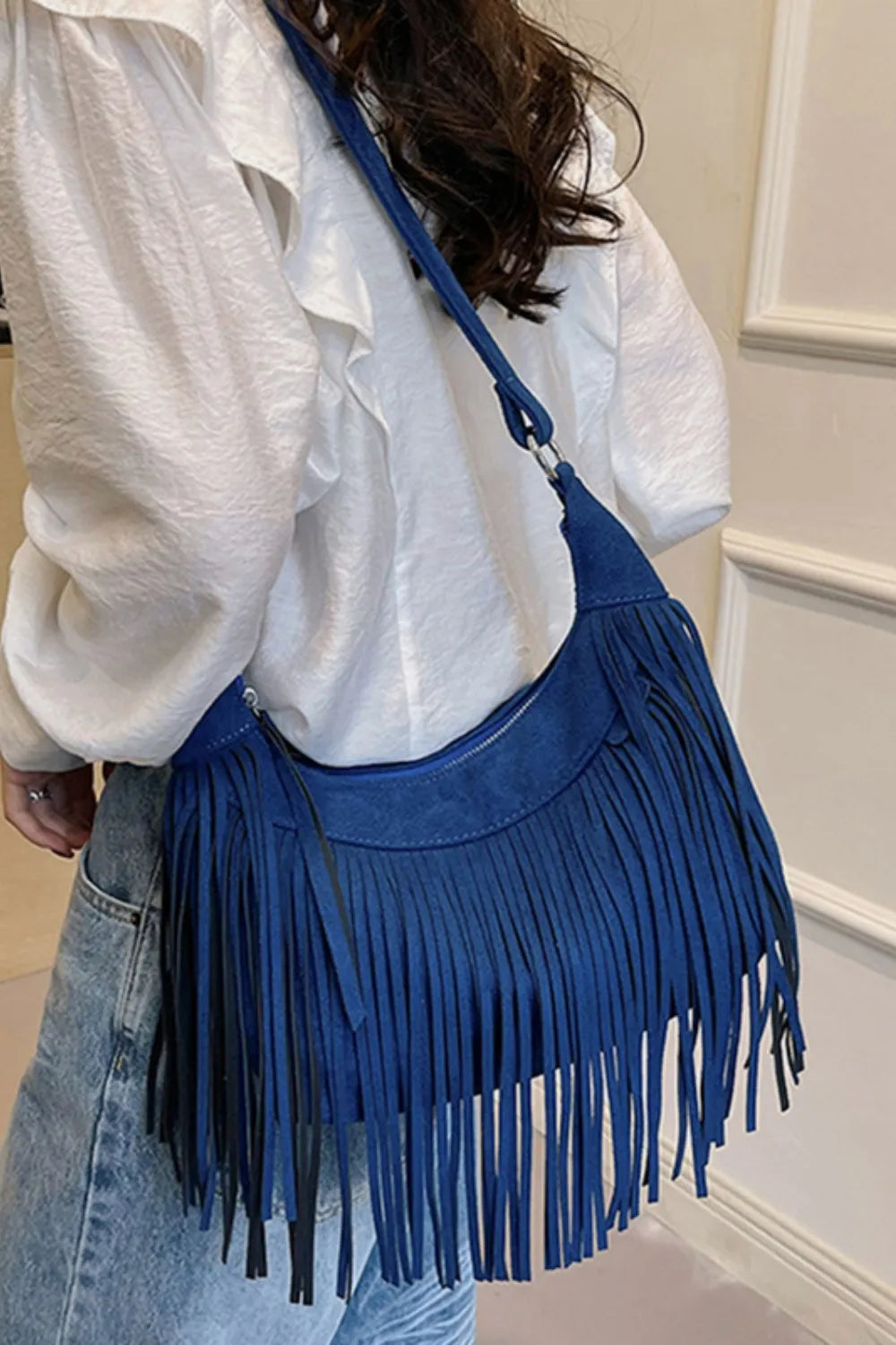 Suede Fringe Adjustable Strap Shoulder Bag showcased in blue, worn casually with a stylish outfit.