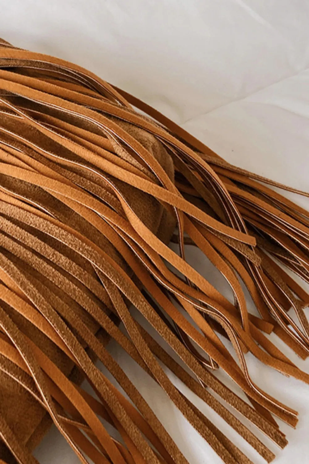 Close-up of suede fringe from the Suede Fringe Adjustable Strap Shoulder Bag showcasing its texture and detail.